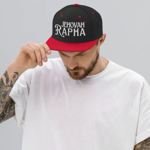 Man wearing black and red Jehovah Rapha flat bill trucker hat