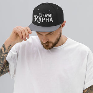 Man wearing black Jehovah Rapha flat bill trucker hat