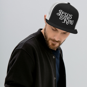 Man wearing black and white Jesus Is King flat bill trucker hat