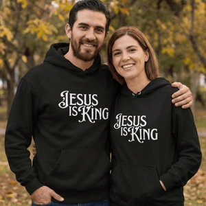 Couple wearing black Jesus Is King Christian hoodies