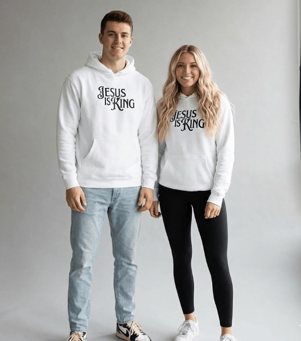 Man and woman wearing white Jesus Is King Christian hoodies